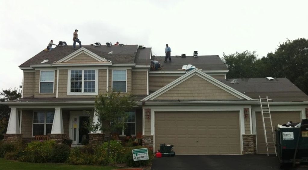 Roofing crew installing shingles