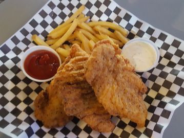 Chicken Tenders in a basket with French Fries and sauces