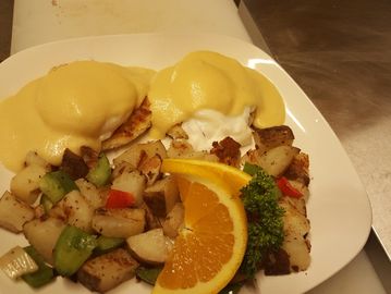 Eggs benedict with potatoes o'brien on a plate