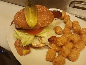 Dagwood Burger with a Fried egg with Tater Tots on a plate