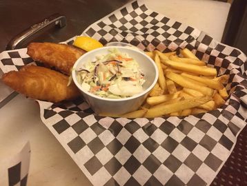 Fish basket with coleslaw and french fries in a basket