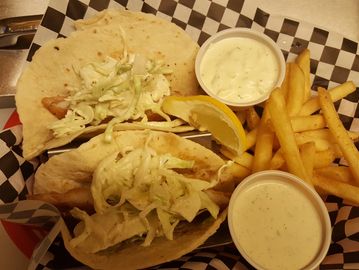 2 fish tacos with french fries in a basket