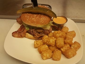 bACON CHEESE Hamburger on a plate WITH TATER TOTS