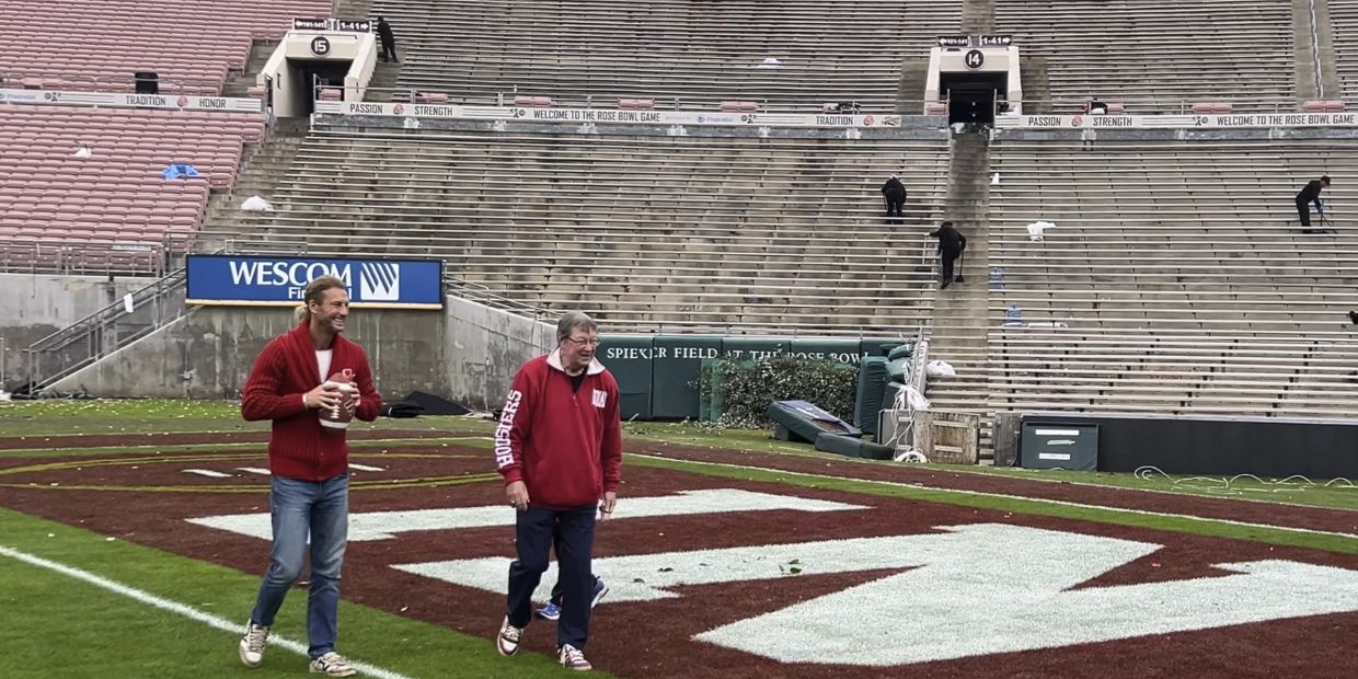 Two men standing on a football field near the end zone.