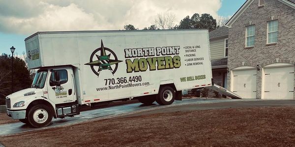 A North Point Movers truck parked outside a house with a loading ramp down home moving experts.