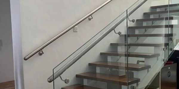 Escalier moderne en bois avec garde-corps en verre.