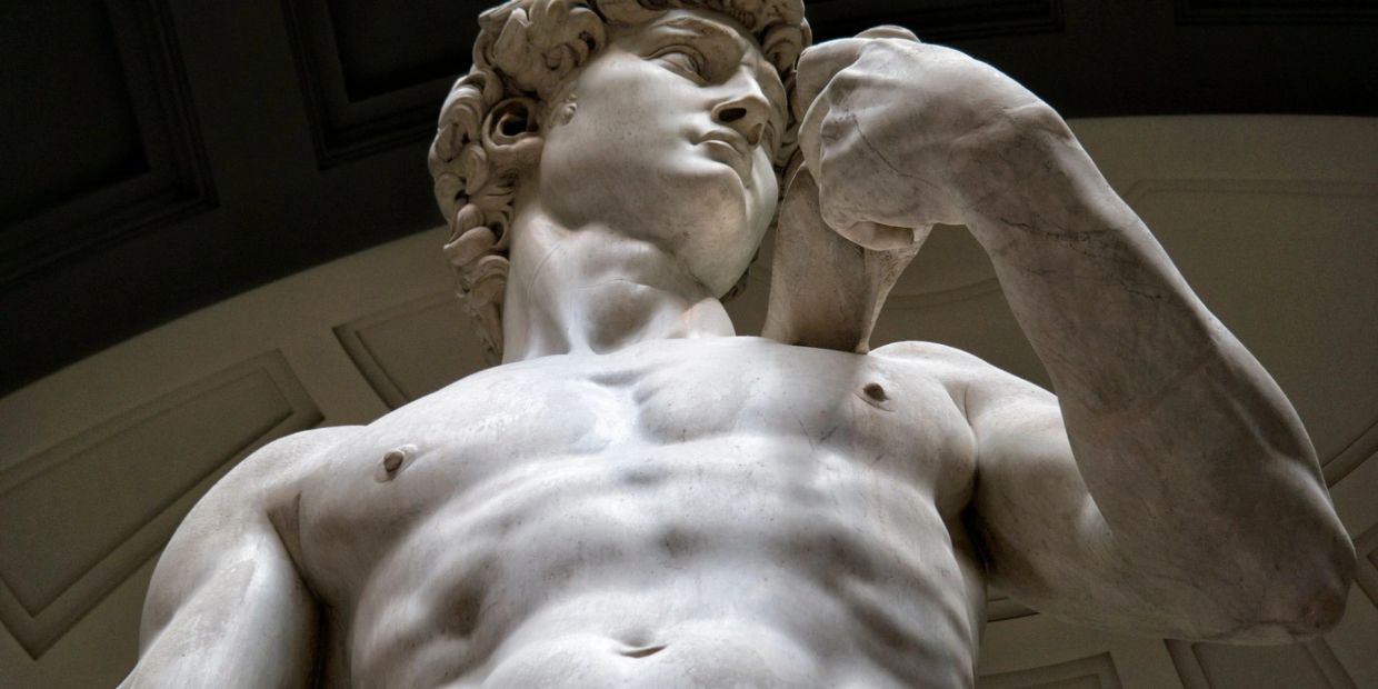 Statua di marmo di un uomo muscoloso in posa.