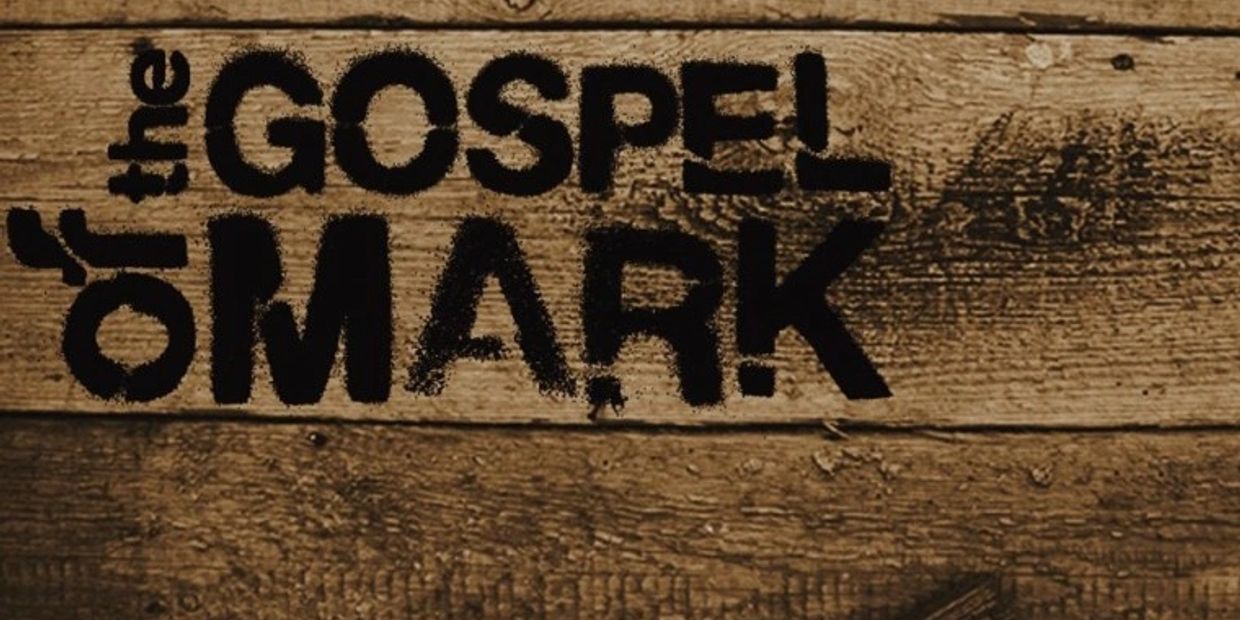 Text reading 'of the GOSPEL MARK' on a wooden surface.