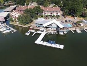 A lakeside marina with docks and boats near residential buildings.