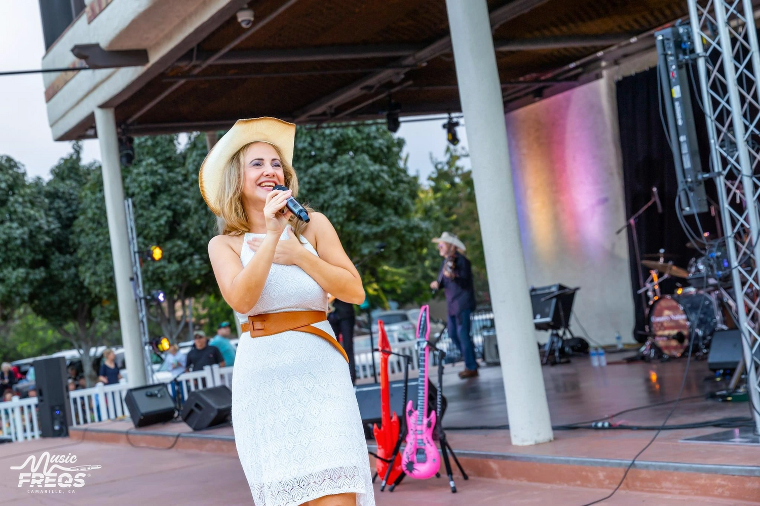 Stacey Anne smiling while holding a microphone. 