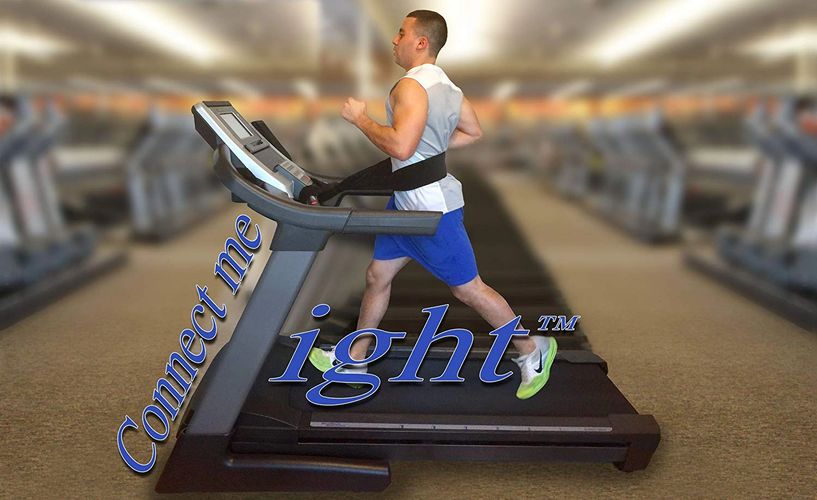 a man at the gym is running on  a treadmill using safety belt around his waist