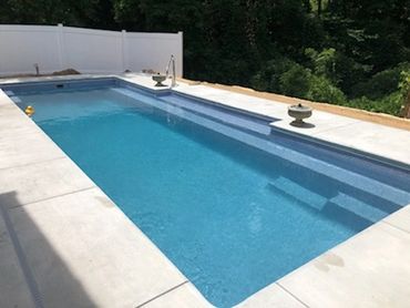 Empty rectangular swimming pool with clear water.