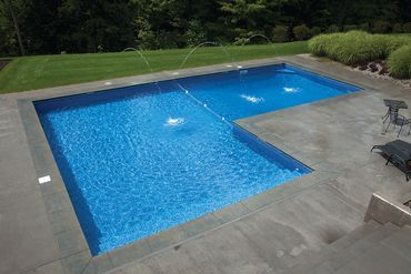 Modern backyard swimming pool with water fountains.