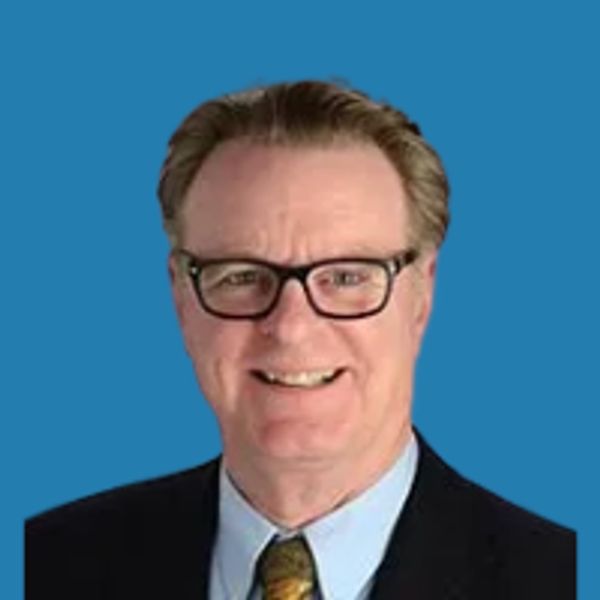 Smiling man with glasses in business attire.
