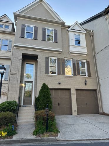 Modern townhouse with double garage and beige brick exterior.
