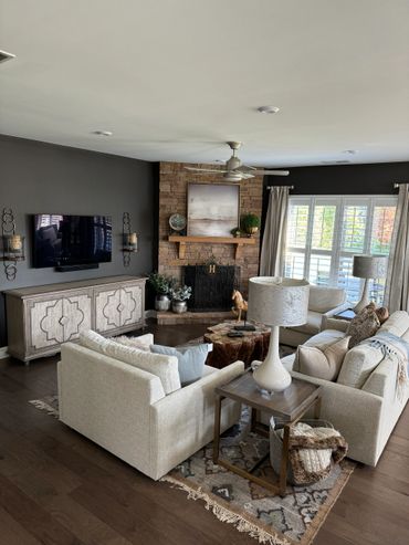 Cozy living room with beige sofas and stone fireplace.
