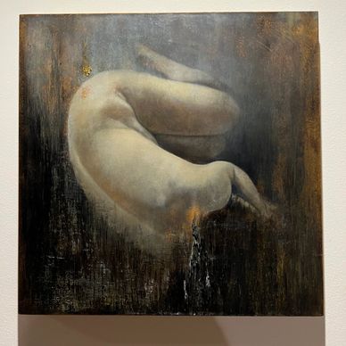 Una figura humana desnuda en una posición fetal sobre un fondo oscuro.