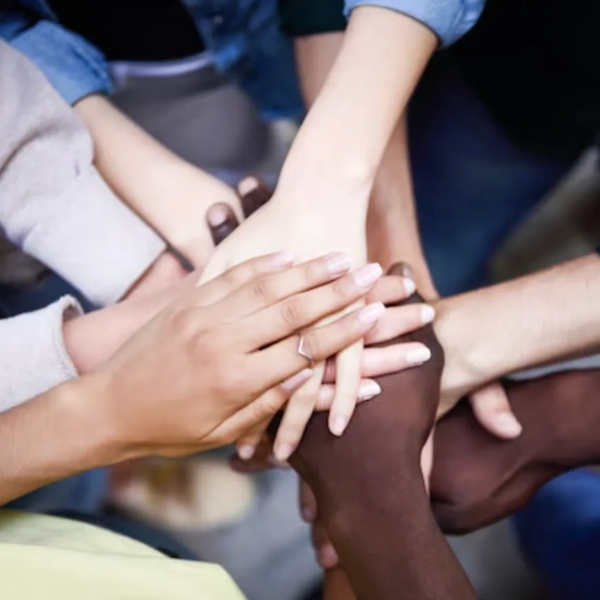 Diverse hands stacked together showing unity and teamwork.