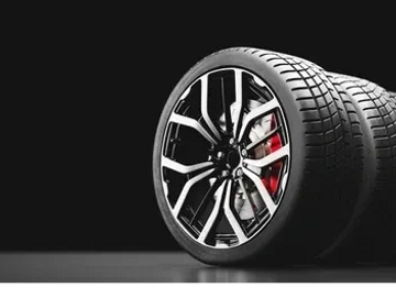 A set of sleek car tires with alloy rims on a black surface.
