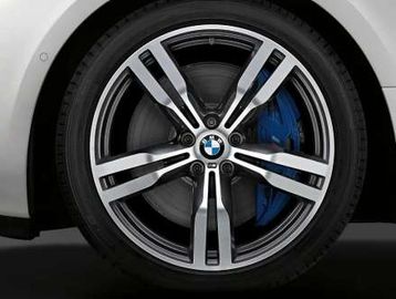 Close-up of a BMW car wheel with a sleek alloy rim and blue brake caliper.