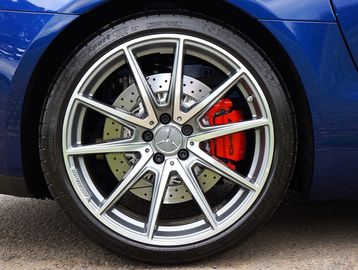 Close-up of a Mercedes AMG car wheel with red brake caliper.