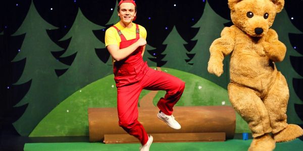 The actor playing Jamie and the actor dressed as Little Bear are dancing