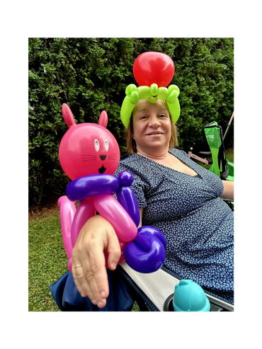 Femme heureuse de sa magnifique couronne de reine de coeur et de son bracelet chat en ballons