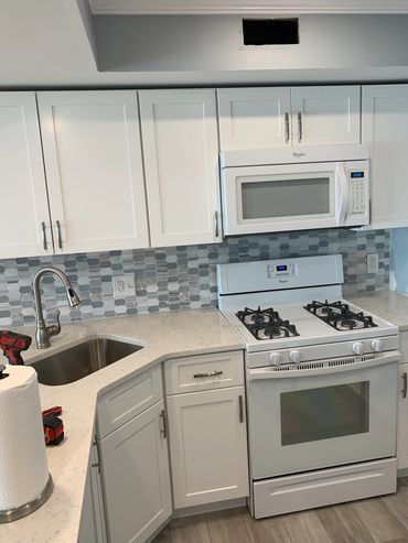 Kitchen remodel, new laminate flooring, cabinets and tile backsplash.