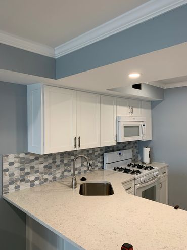 Kitchen remodel, new laminate flooring, cabinets and tile backsplash. Crown moulding added as well.