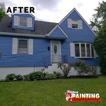 Freshly painted blue house with white trim and neat landscaping.