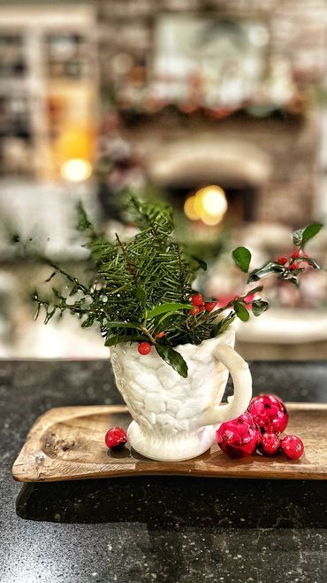 Spruce sprigs in a sugarbowl for holiday decor.