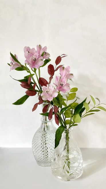 Floral and greenery stems in a pair of crystal decanters