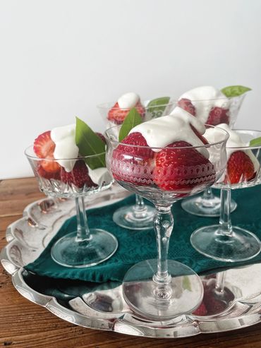 Strawberries and cream served in vintage champagne goblets, served on a silver tray.