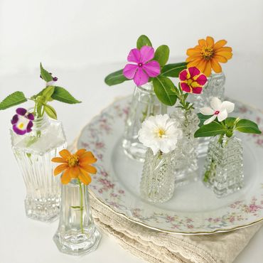 Individual fresh flowers in crystal salt shakers are perfect as decorations on a buffet table