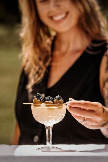 Bartender serving a caviar martini in a vintage champagne coupe at a wedding
