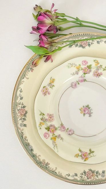 Layered vintage plates with a few garden blossoms
