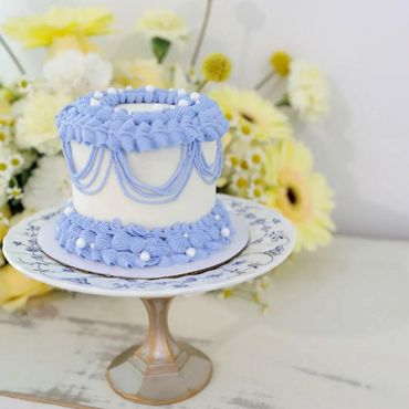 Two layer decorated cake on a vintage footed plate