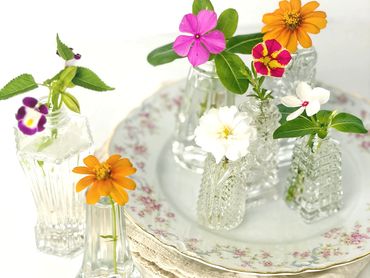 Assorted vintage salt shakers make perfect individual vases for a place setting bloom