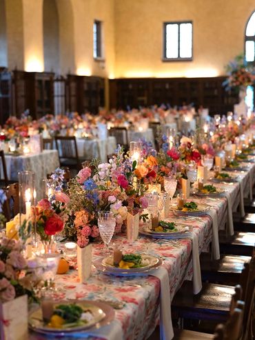 Banquet tables set with vintage china, glassware, silverware, flowers and candlelight.