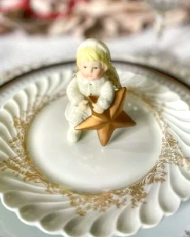Holiday table set with a vintage porcelain figurine on the dining plate at each guest's place settin