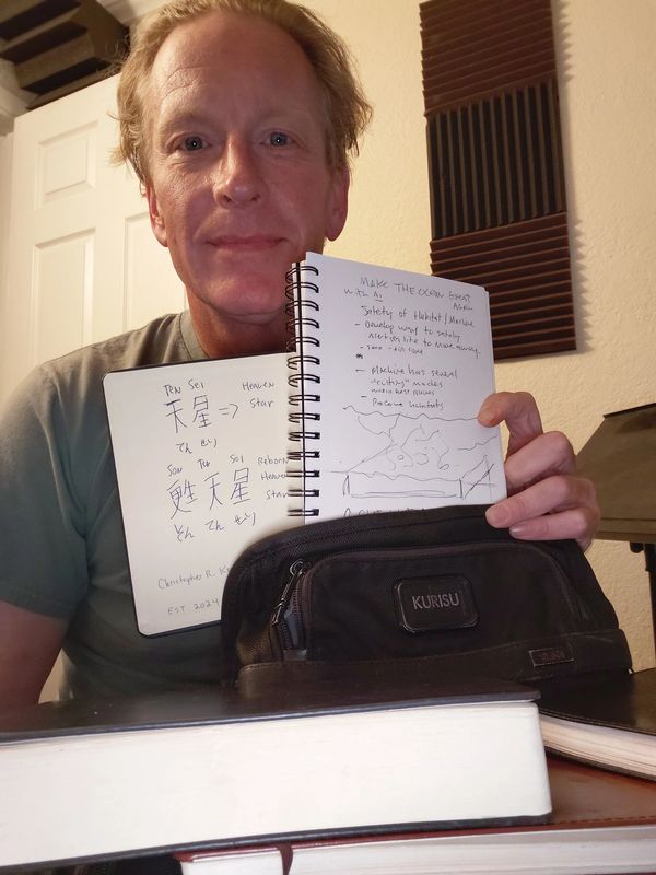 Man holding notebook with handwritten notes and sketch.