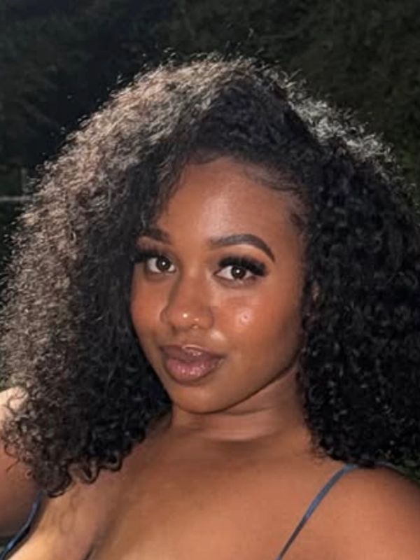 Woman with curly hair looking confidently at the camera.