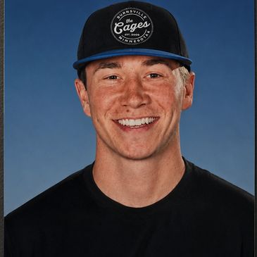 Smiling young man in a cap and black shirt.
