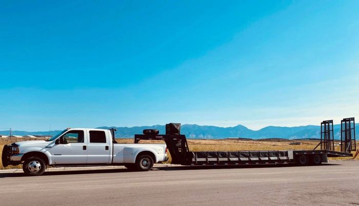 1999 Ford F-350 crew cab dual rear drive truck connected via Gooseneck hitch to Mustang mobile Dyno