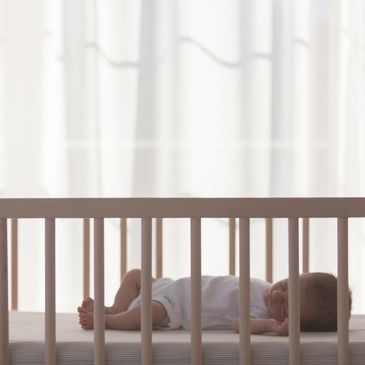 Sleep-trained baby sleeping in their crib independently without help