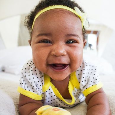 Happy baby crawling out of bed in the morning, well-rested from sleeping through the night.