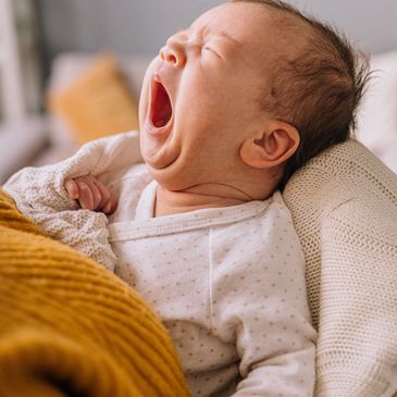 Baby yawning and waking up from short, irregular naps during wake windows.