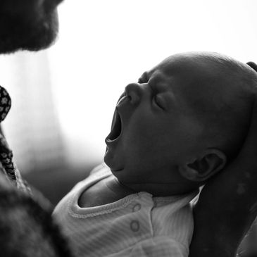 Baby yawning in the early morning, showing signs of sleepiness.