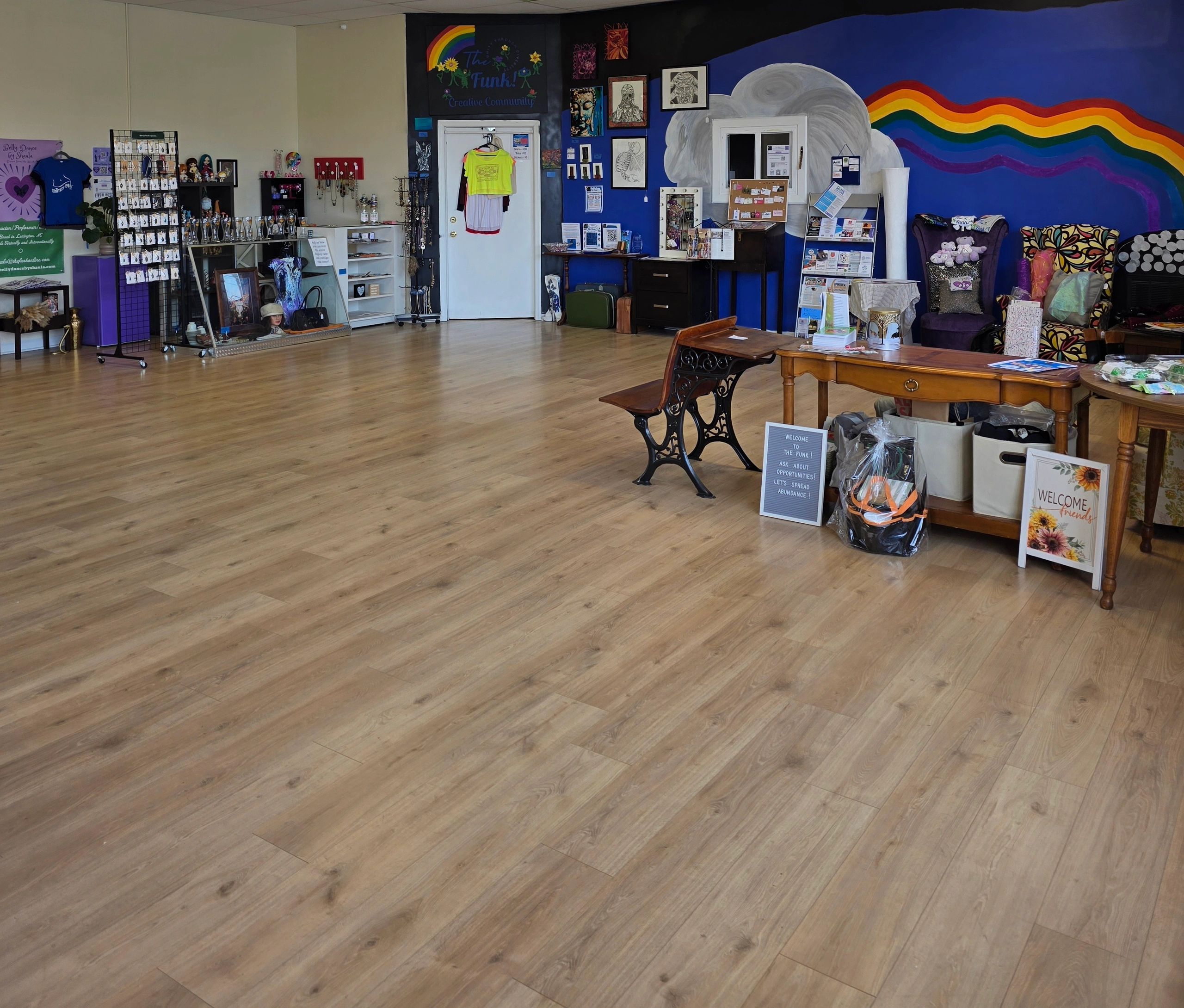 Colorful community space with artwork, merchandise, and welcoming signs.
