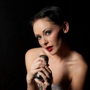 Photo by J Victoria Exposures
Model holding vintage microphone and looking into the camera.